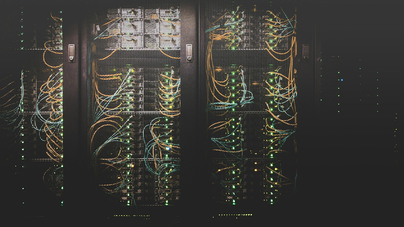 Rows of server racks in a data centre, lit by small indicator LEDs